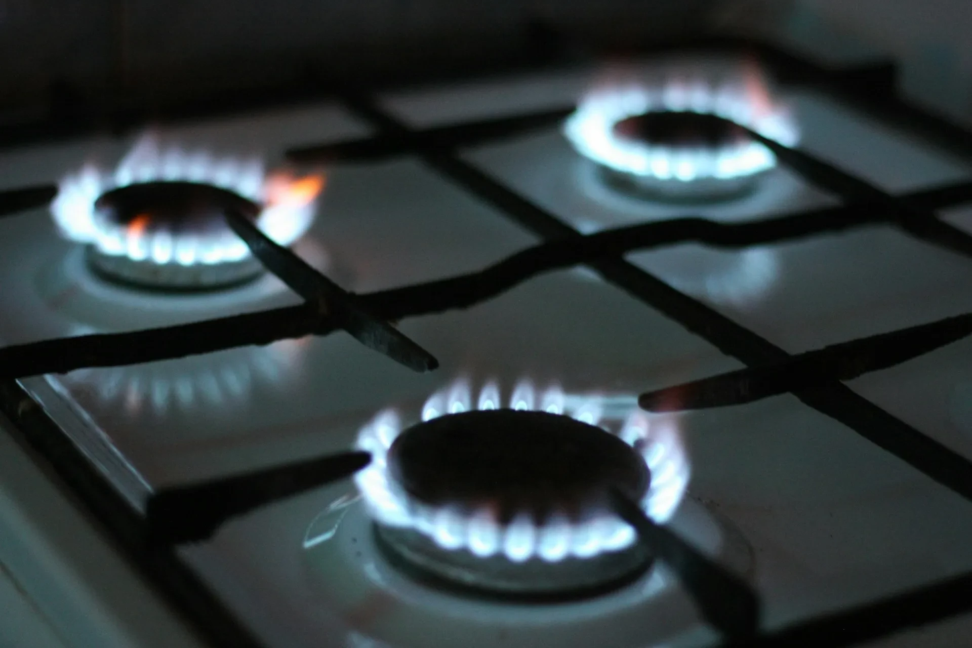 Brennende Gasflammen auf einem Gasherd in der Dunkelheit